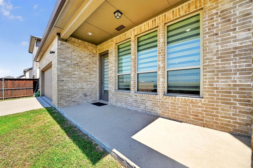 Covered patio featuring a brick exterior, concrete flooring, recessed lighting, and multiple windows with integrated blinds