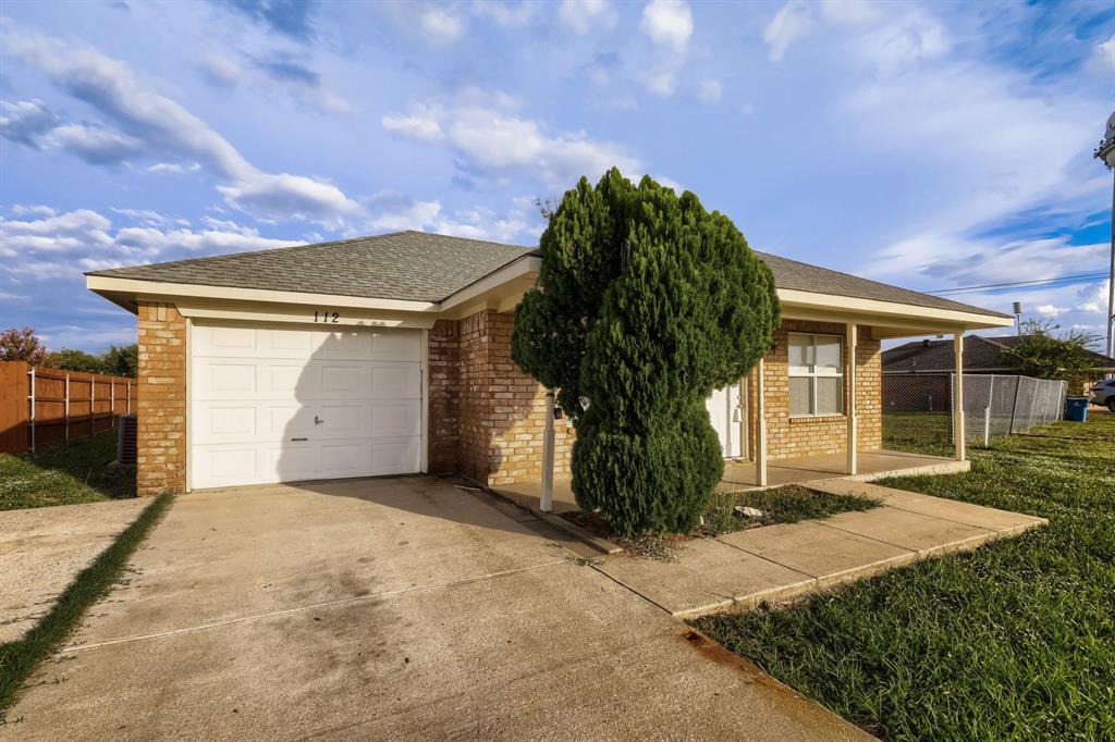 Single-story brick exterior featuring a hip roof, covered front porch, concrete driveway, and a one-car garage