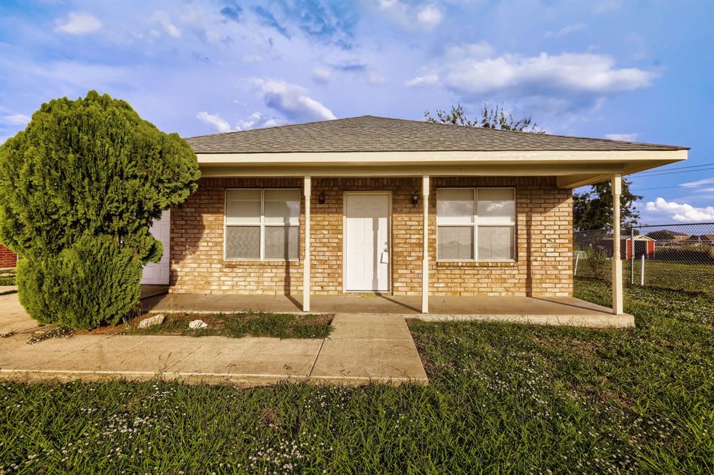 Single-story brick exterior featuring a covered front porch, asphalt shingle roof, and a concrete walkway Single-story brick exterior featuring a covered front porch, asphalt shingle roof, and a concrete walkway
