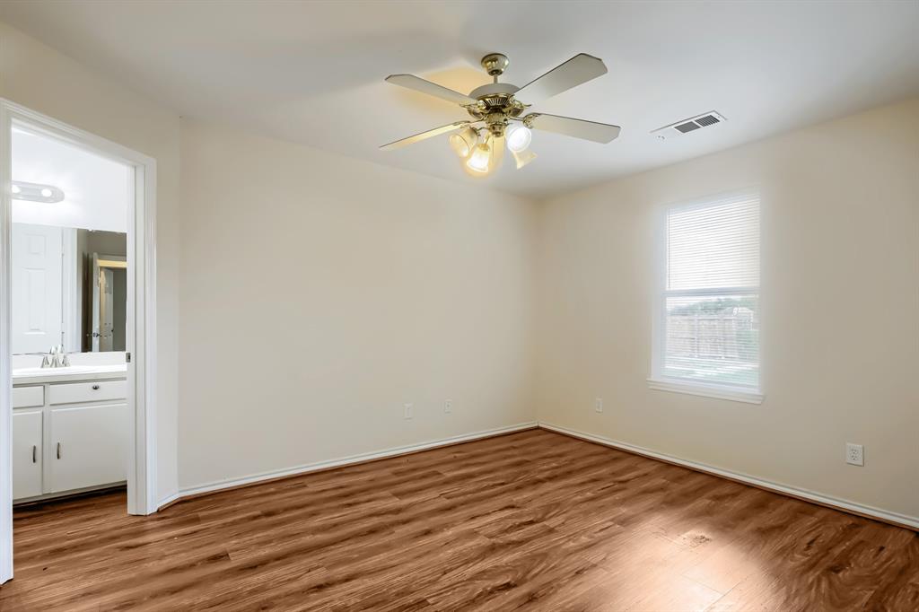 Room featuring wood-finish flooring, a multi-blade ceiling fan with integrated lighting, and a single-hung window with white casing