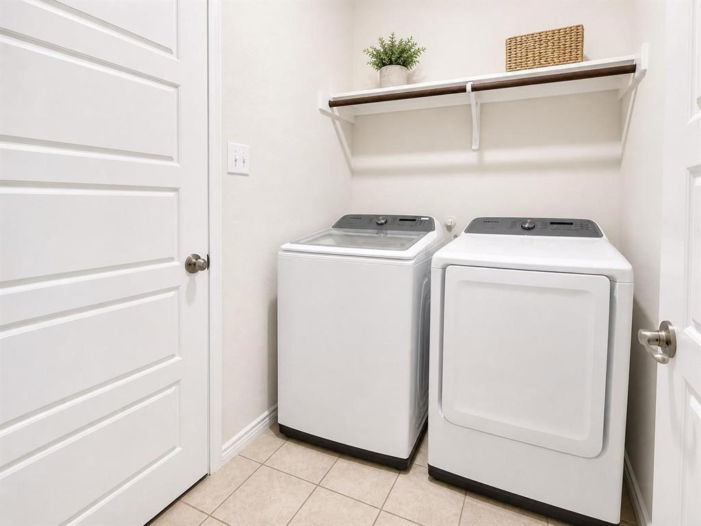 Full-size washer and dryer area with shelving