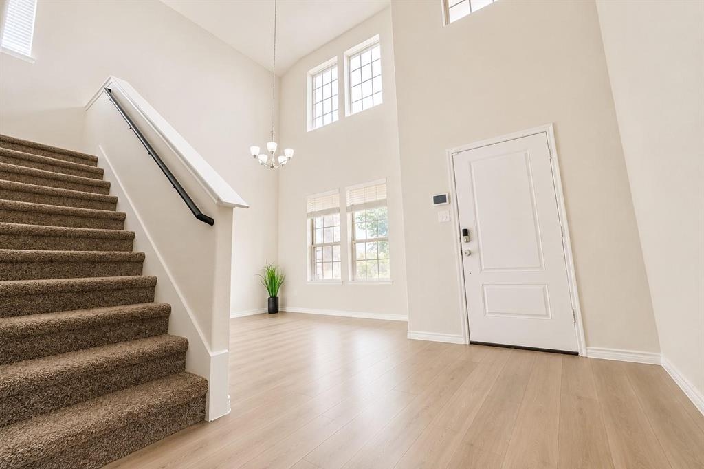 Entryway boasts vaulted ceilings and elegant stairway
