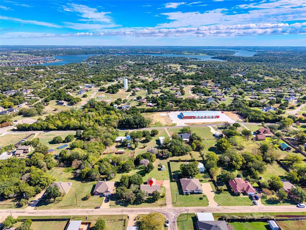 Aerial perspective of a detached residential property situated on a lot with established trees and expansive lawn space