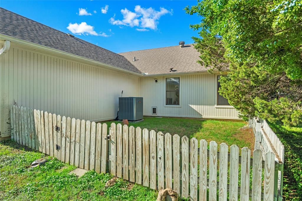 Exterior featuring vertical siding, shingled roofing, and an enclosed fenced yard