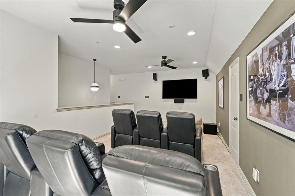 Recessed lighting, dual matte black ceiling fans, wall-mounted speakers, and a contemporary spherical pendant light