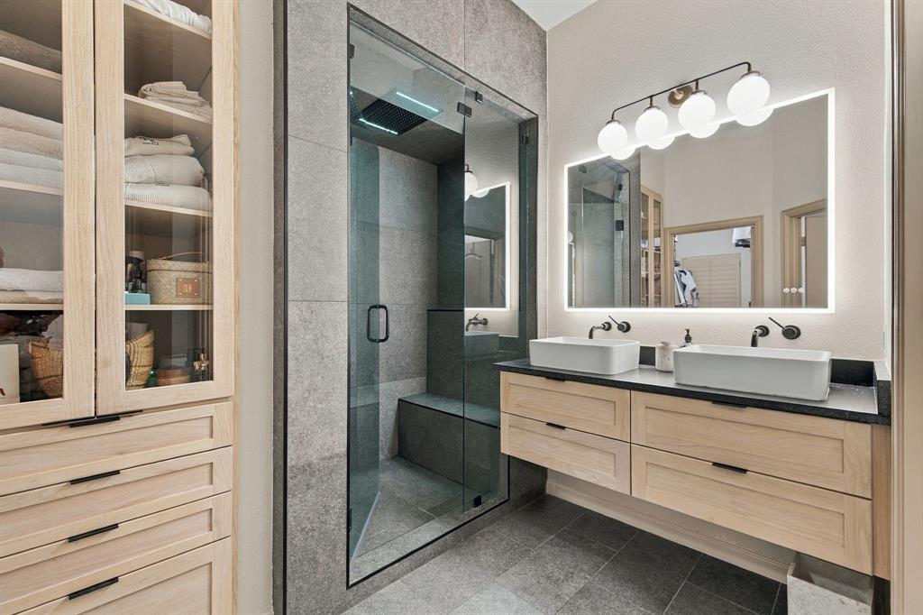 Floating dual-vanity with light-toned wood cabinetry, rectangular vessel sinks, and matte black wall-mounted faucets