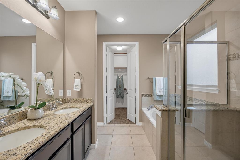 Pub-height dual sinks, a 4-ft shower stall and deep soaking tub.