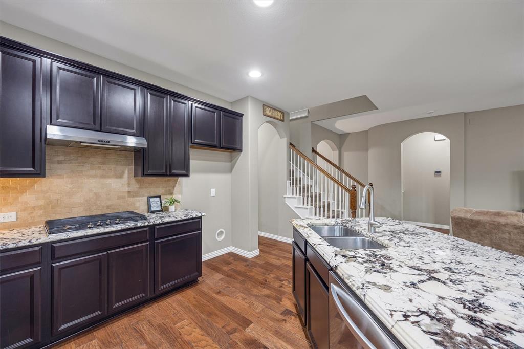 Gourmet kitchen featuring 5-burner gas range, stainless steel appliances and a gorgeous designer granite island.
