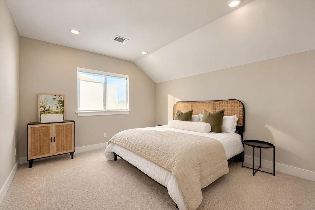 With a vaulted ceiling and a spacious layout, this guest bedroom easily accommodates full bedroom furniture while leaving plenty of room to stretch out