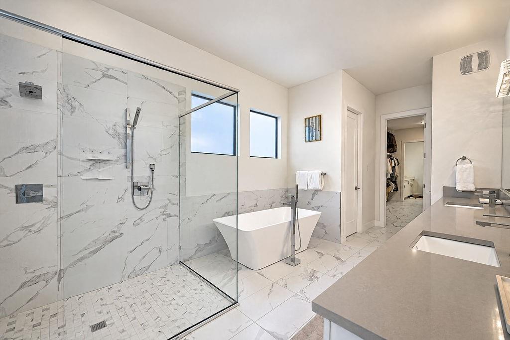 The spa-inspired primary bath features a standalone soaking tub and a spacious walk-in shower for ultimate evening unwind time