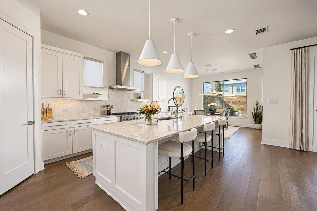 The chef's kitchen features a massive center island with a breakfast bar, offering a natural gathering spot for morning coffee or casual evening meals