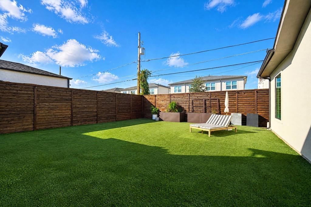 Soaking up the Texas sunshine or tossing a ball around takes zero prep work in this low-maintenance turfed backyard