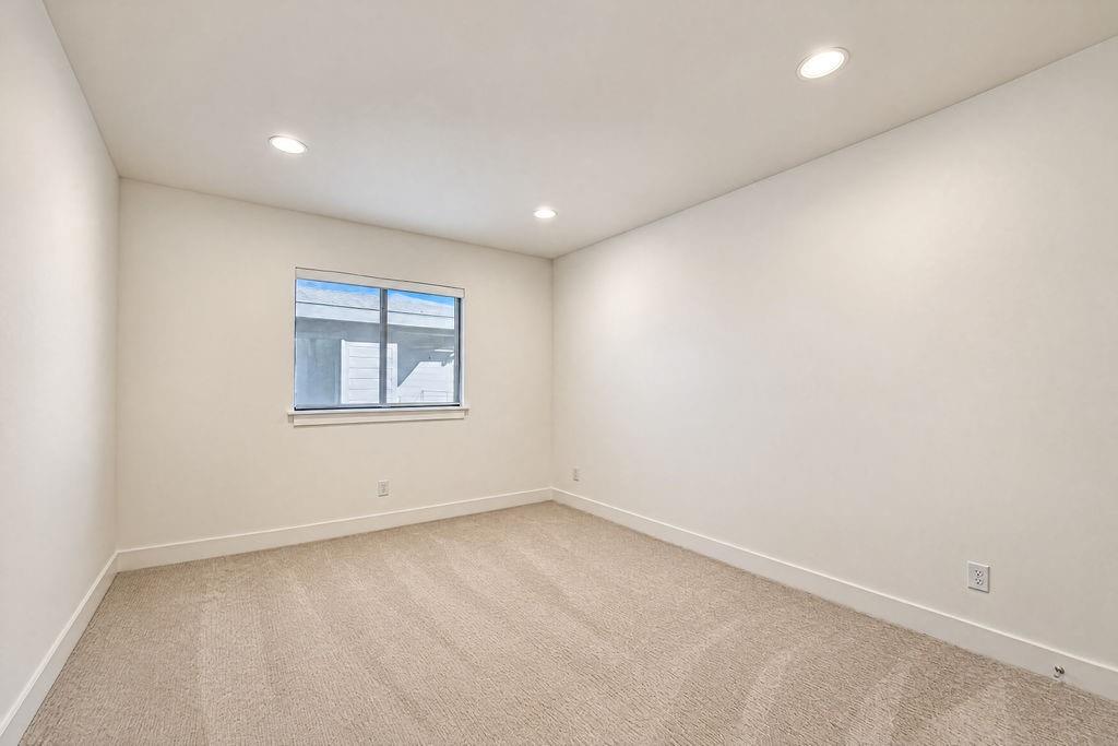 Sunlight fills this spacious upstairs guest room, creating an inviting space where family or visitors can relax and recharge in comfort