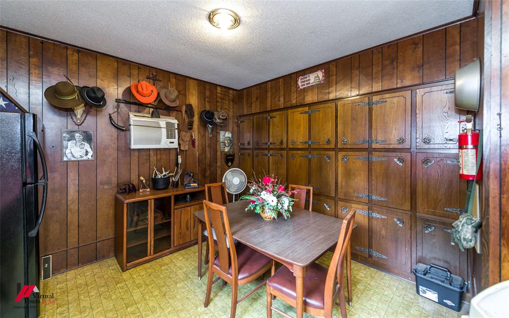 Wood-paneled walls and extensive floor-to-ceiling built-in cabinetry featuring ornate metal hardware