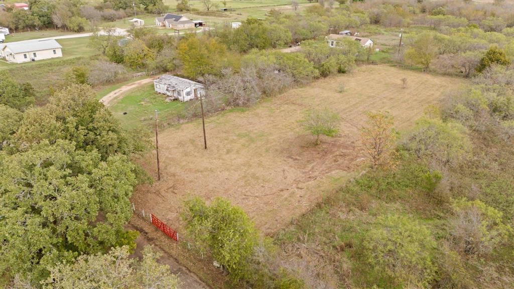 Expansive acreage featuring mature trees, a cleared grass expanse, and utility poles on-site Expansive acreage featuring mature trees, a cleared grass expanse, and utility poles on-site
