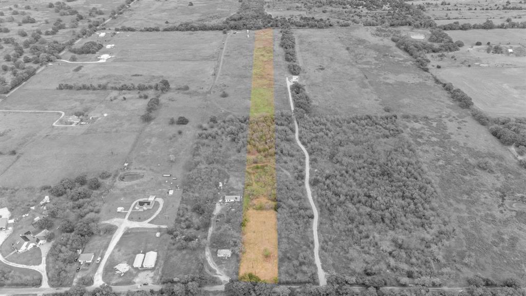 Expansive acreage featuring cleared land, mature tree clusters, and direct access to an established gravel path