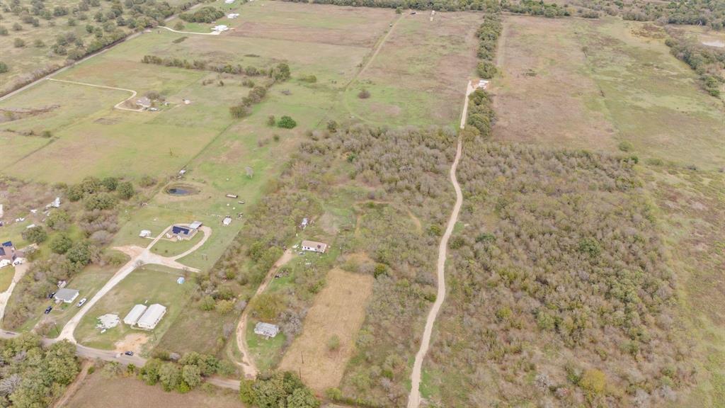 Expansive rural acreage featuring cleared pastureland, dense clusters of mature trees, and existing unpaved trail access Expansive rural acreage featuring cleared pastureland, dense clusters of mature trees, and existing unpaved trail access