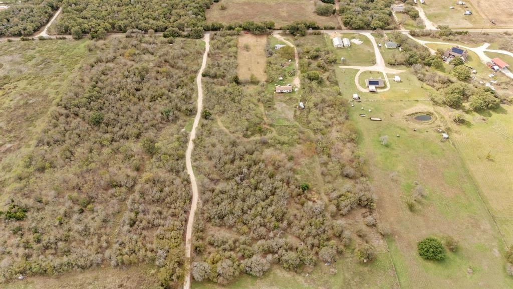 Expansive acreage featuring mature trees, natural vegetation, and an existing dirt access path Expansive acreage featuring mature trees, natural vegetation, and an existing dirt access path