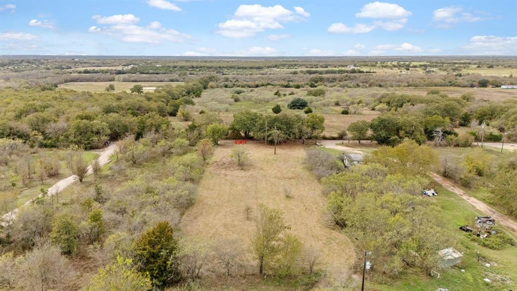 Expansive lot featuring mature trees, native vegetation, and dirt road access