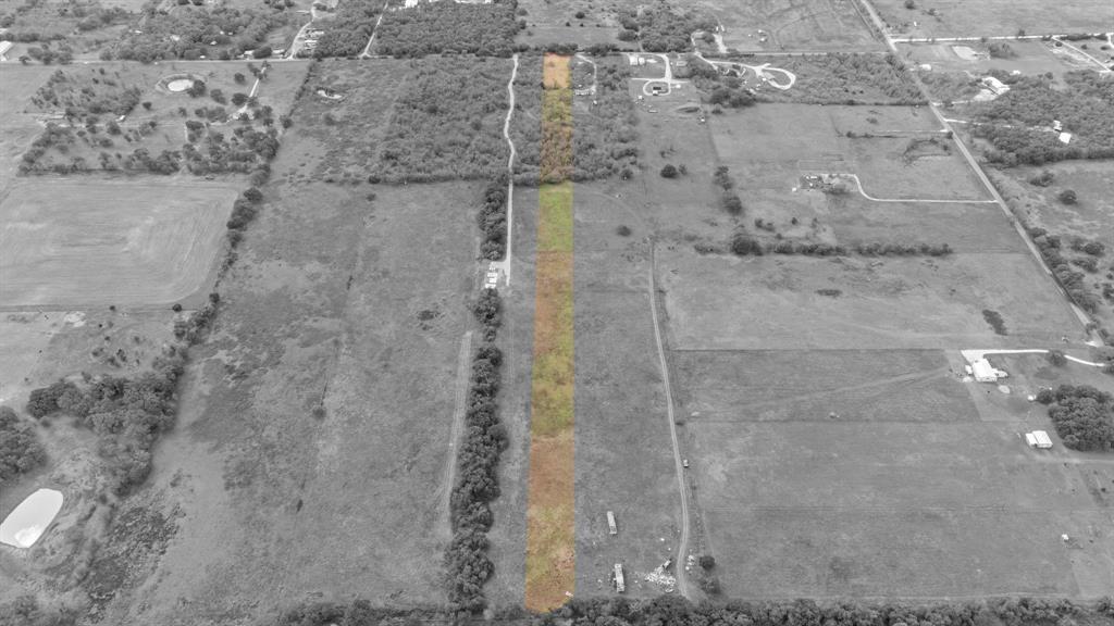 Aerial perspective of a rectangular parcel featuring cleared land, native grasses, and mature perimeter trees