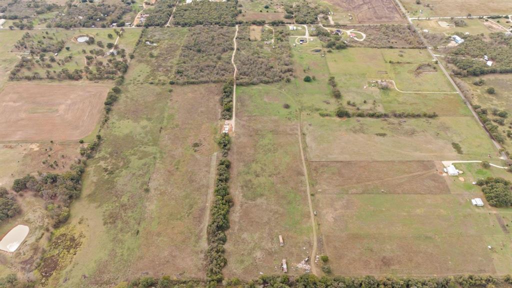 Expansive acreage featuring cleared pasture land, dense clusters of mature trees, and established unpaved access paths Expansive acreage featuring cleared pasture land, dense clusters of mature trees, and established unpaved access paths