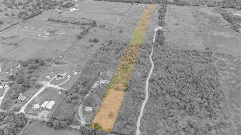 Aerial perspective of expansive acreage featuring open grasslands and clusters of mature trees