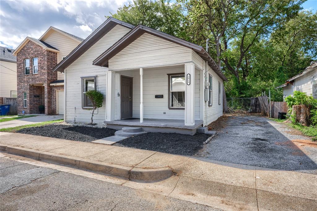 Single-story residence featuring horizontal lap siding, a covered front porch with square columns, and a dedicated side-driveway parking area