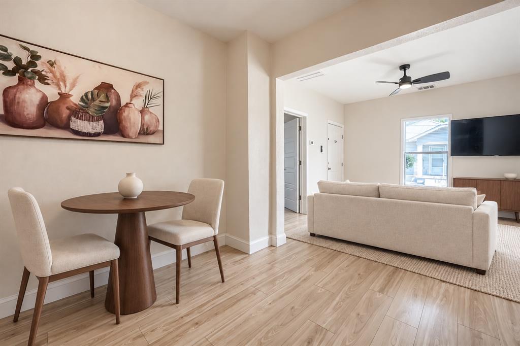 Neutral wall tones, wood-finish flooring, and a ceiling fan with integrated lighting