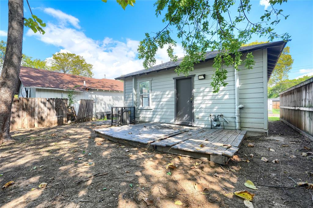Rear exterior featuring horizontal lap siding, a ground-level wood deck, and wood privacy fencing