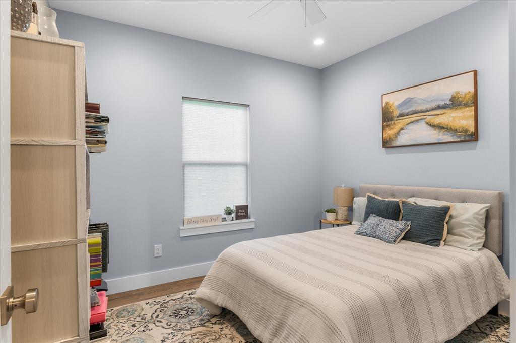 Room featuring light-toned interior paint, wood-finish flooring, ceiling fan, and a deep-set window ledge