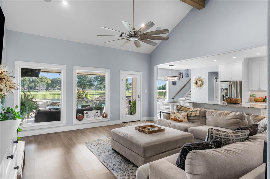 Vaulted ceilings, wood-finish flooring, recessed lighting, multi-pane windows, and a ceiling fan