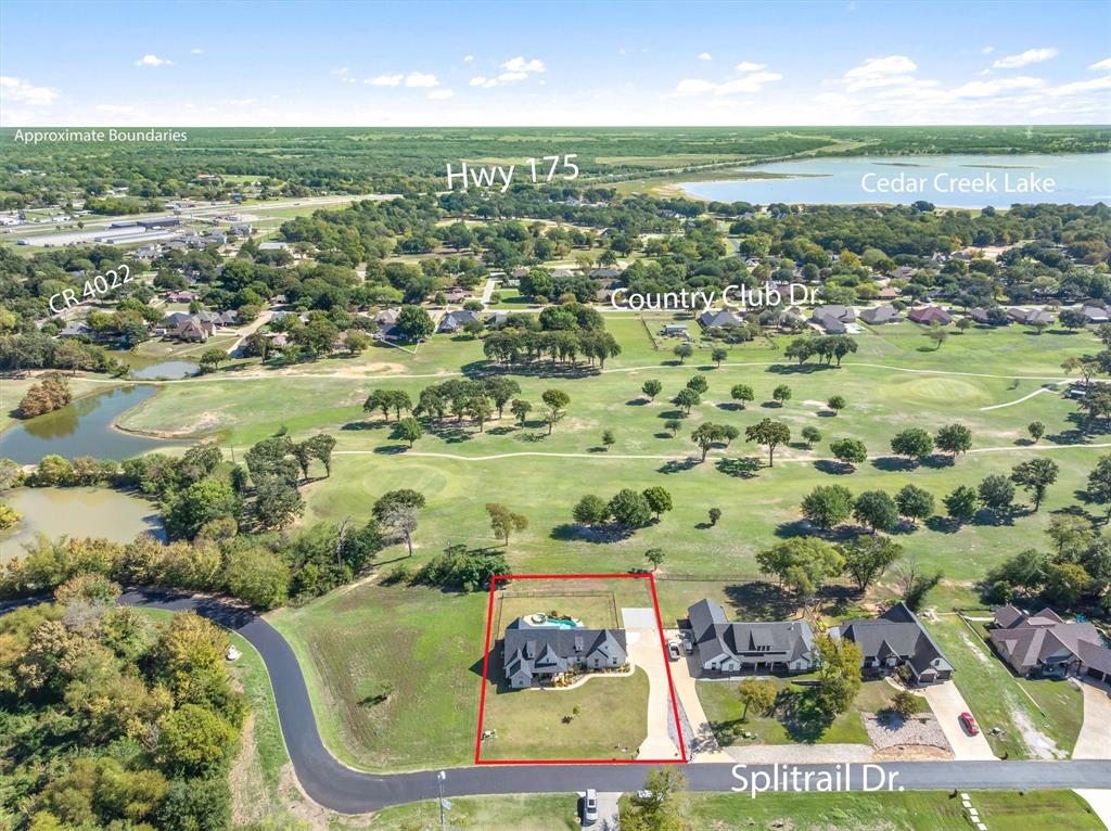 Aerial view of property situated on a corner lot featuring a rear in-ground swimming pool, direct proximity to a golf course, and mature tree-lined surroundings Aerial view of property situated on a corner lot featuring a rear in-ground swimming pool, direct proximity to a golf course, and mature tree-lined surroundings