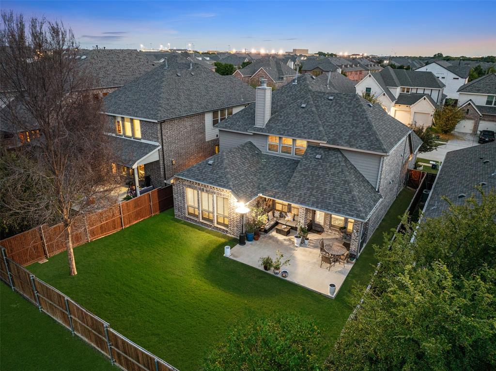 Backyard featuring a paved stone patio, fenced perimeter, and grass lawn