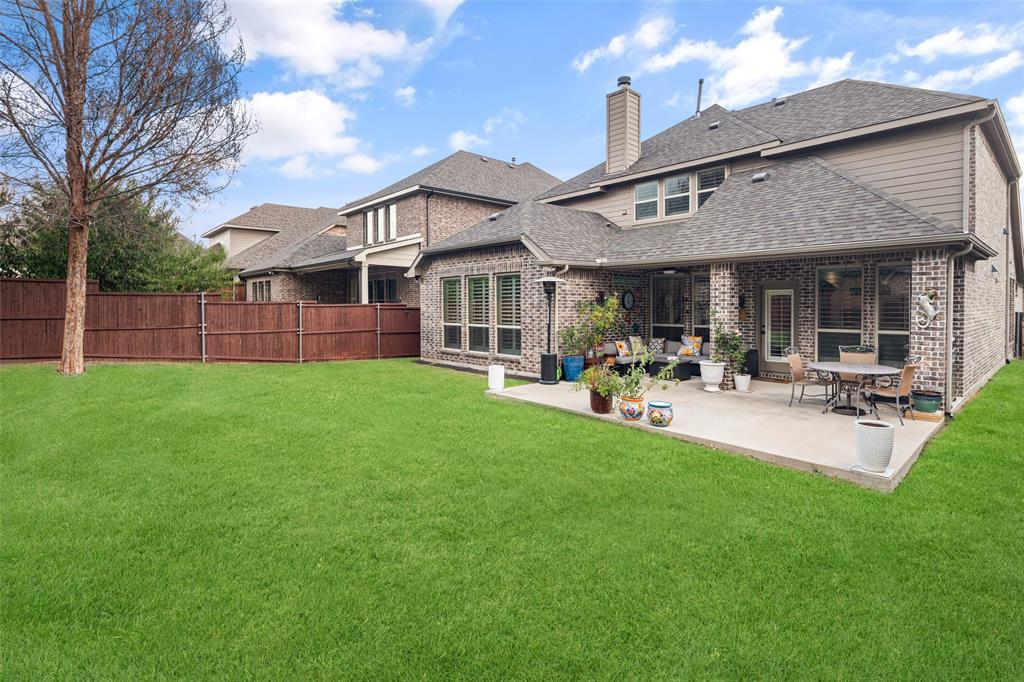Backyard featuring a manicured lawn, concrete patio, and a wood privacy fence