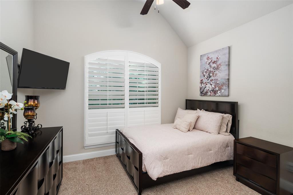 Vaulted ceiling, arched window with interior shutters, and a ceiling fan