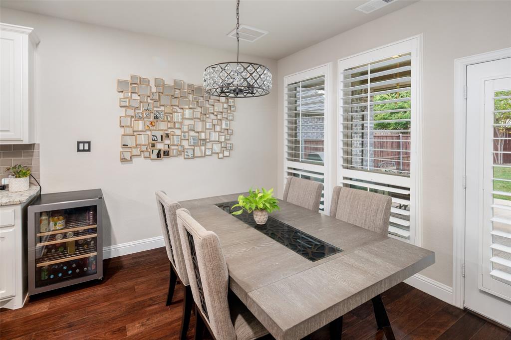 Hardwood flooring, plantation shutters, built-in under-counter beverage refrigerator, and drum-style crystal pendant light
