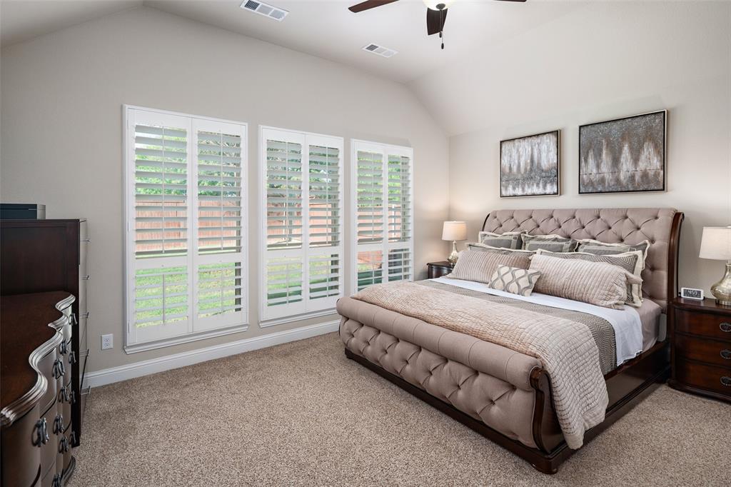 Vaulted ceiling, carpeting, and plantation shutters featuring triple-pane windows