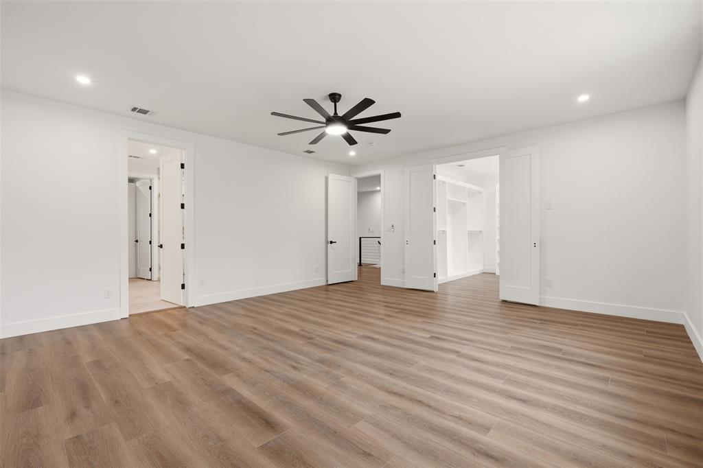 Wood-finish flooring, recessed lighting, matte black ceiling fan, and multi-panel interior doors