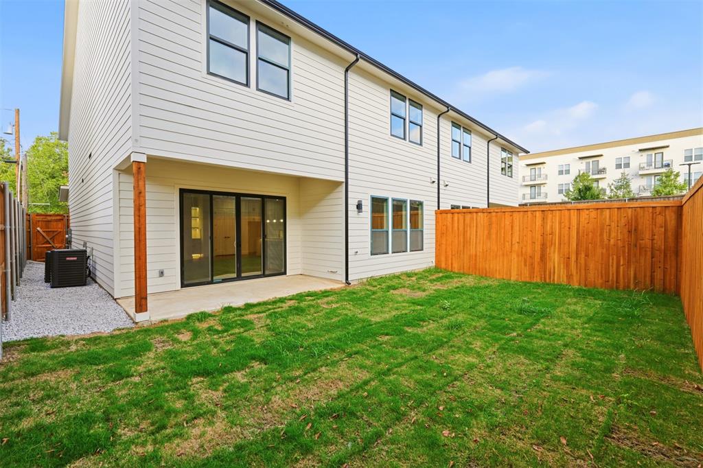 Exterior featuring horizontal lap siding, a covered concrete patio, sliding glass doors, a wood privacy fence, and a gravel side yard