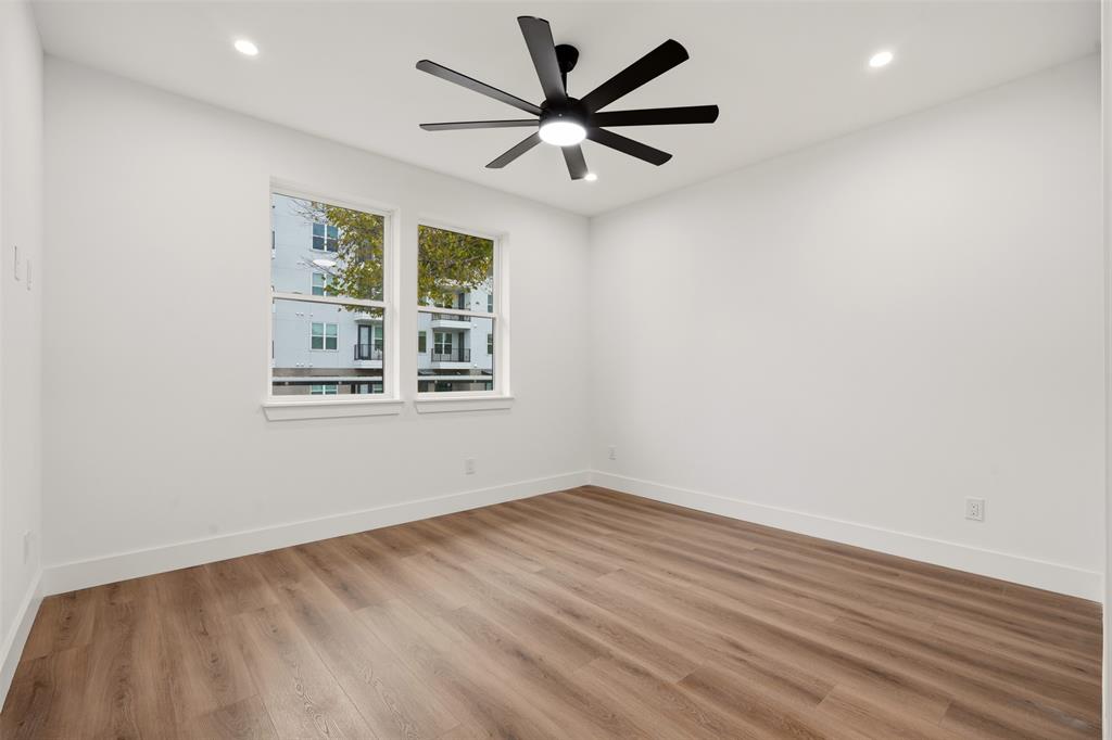 Interior space featuring wood-finish flooring, recessed lighting, and a multi-blade ceiling fan with integrated light