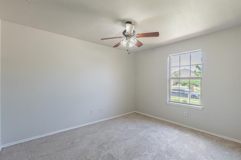 Carpeted interior space featuring a ceiling fan with integrated lighting, a multi-pane window, and light-toned walls