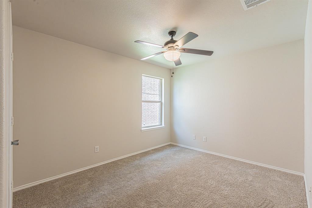 Carpeted room with a ceiling fan light fixture, single window, and neutral wall paint