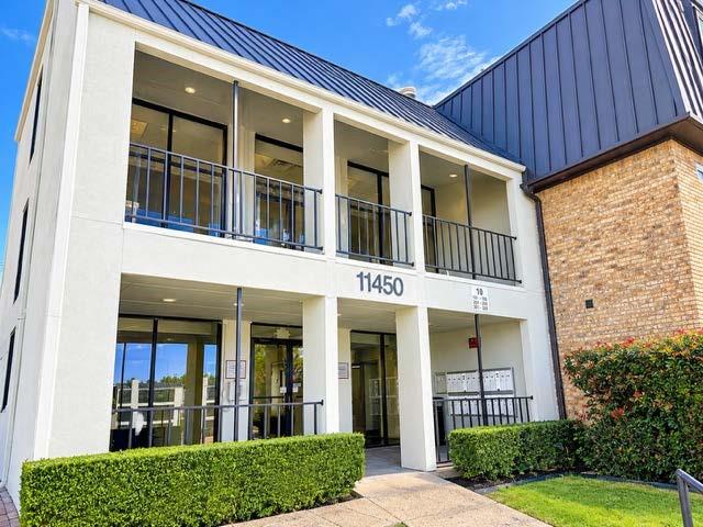 Multi-level exterior featuring a metal roof, stucco facade, second-story balcony with iron railings, and ground-level covered entryway Multi-level exterior featuring a metal roof, stucco facade, second-story balcony with iron railings, and ground-level covered entryway