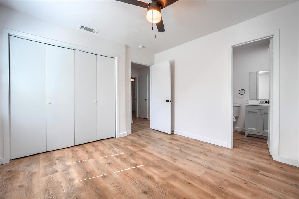 Room featuring wood-finish flooring, a ceiling fan with integrated lighting, and a large bi-fold closet