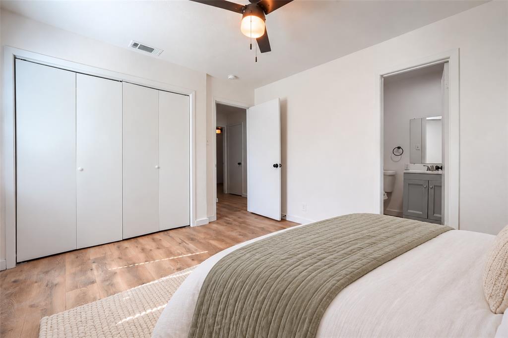 Room featuring wood-finish flooring, a multi-panel sliding closet, and a ceiling-mounted fan with integrated lighting