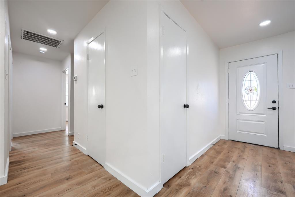 Entryway featuring wood-finish flooring, recessed lighting, and an exterior door with an oval glass insert and matte black hardware