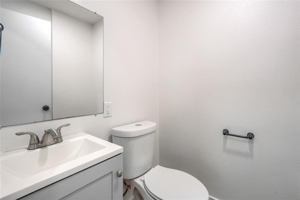 Single-sink vanity with a rectangular basin, polished metal faucet, integrated wall-mounted mirror, and matte black hardware