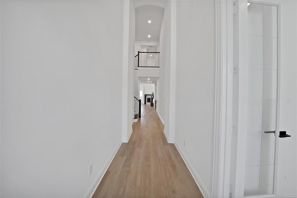Vaulted ceilings, wood-finish flooring, recessed lighting, and a staircase featuring metal balusters