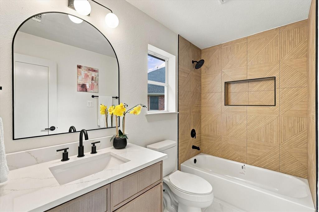 Bathroom featuring a vanity with white stone-finish countertop, undermount sink, and matte black faucet