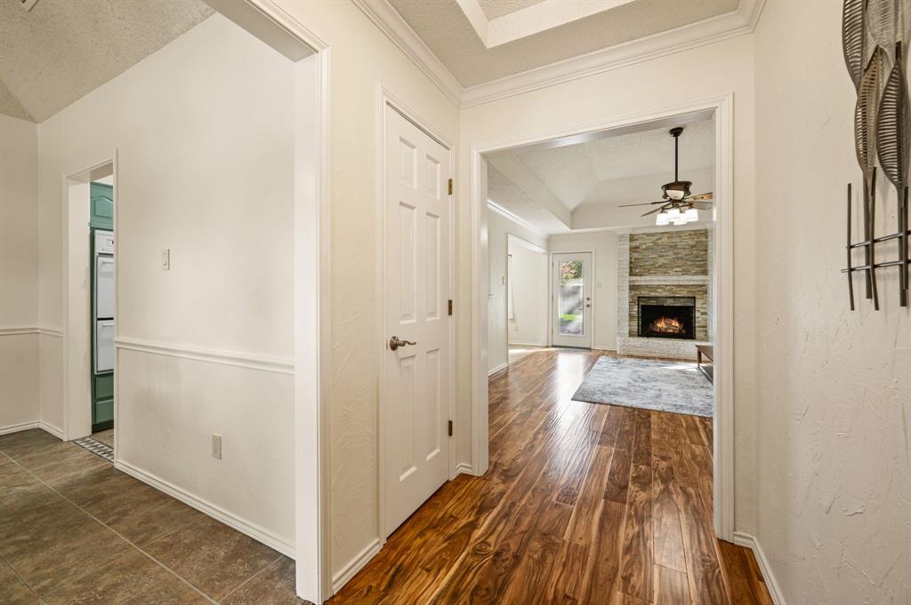 Entryway featuring tile flooring, wood-finish flooring, tray ceilings, and a stacked-stone fireplace